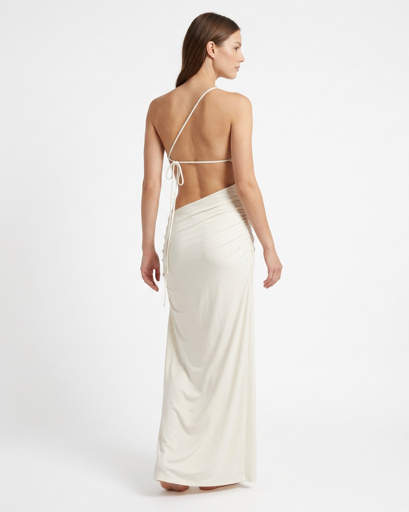 Vestido largo AVRA marfil en modelo, vista posterior con espalda descubierta, tira diagonal y amarre lateral.