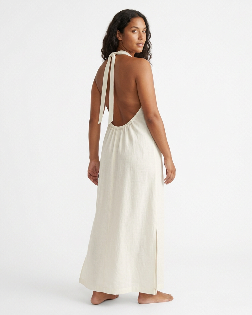 Modelo con vestido largo TULUM marfil, vista posterior con espalda descubierta y tiras anudadas al cuello.