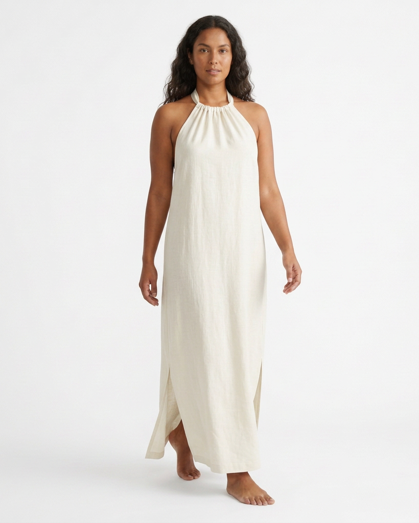Modelo con vestido largo TULUM marfil, vista frontal con cuello halter fruncido y aberturas laterales.
