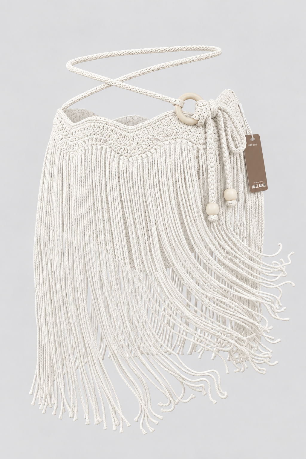Falda MINI TASSEL OLAS crema sin modelo, vista frontal con pretina de ondas tejida a mano, flecos largos, tiras ajustables y aro lateral en tono madera clara.