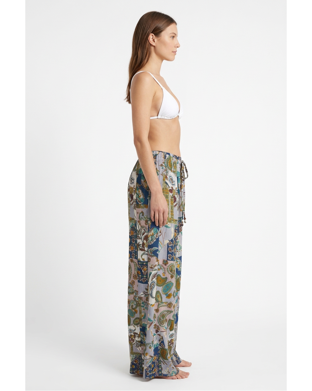 Modelo con pantalón PALAZZO 22’ azul multicolor de MIZZBOGI y top blanco, vista lateral.