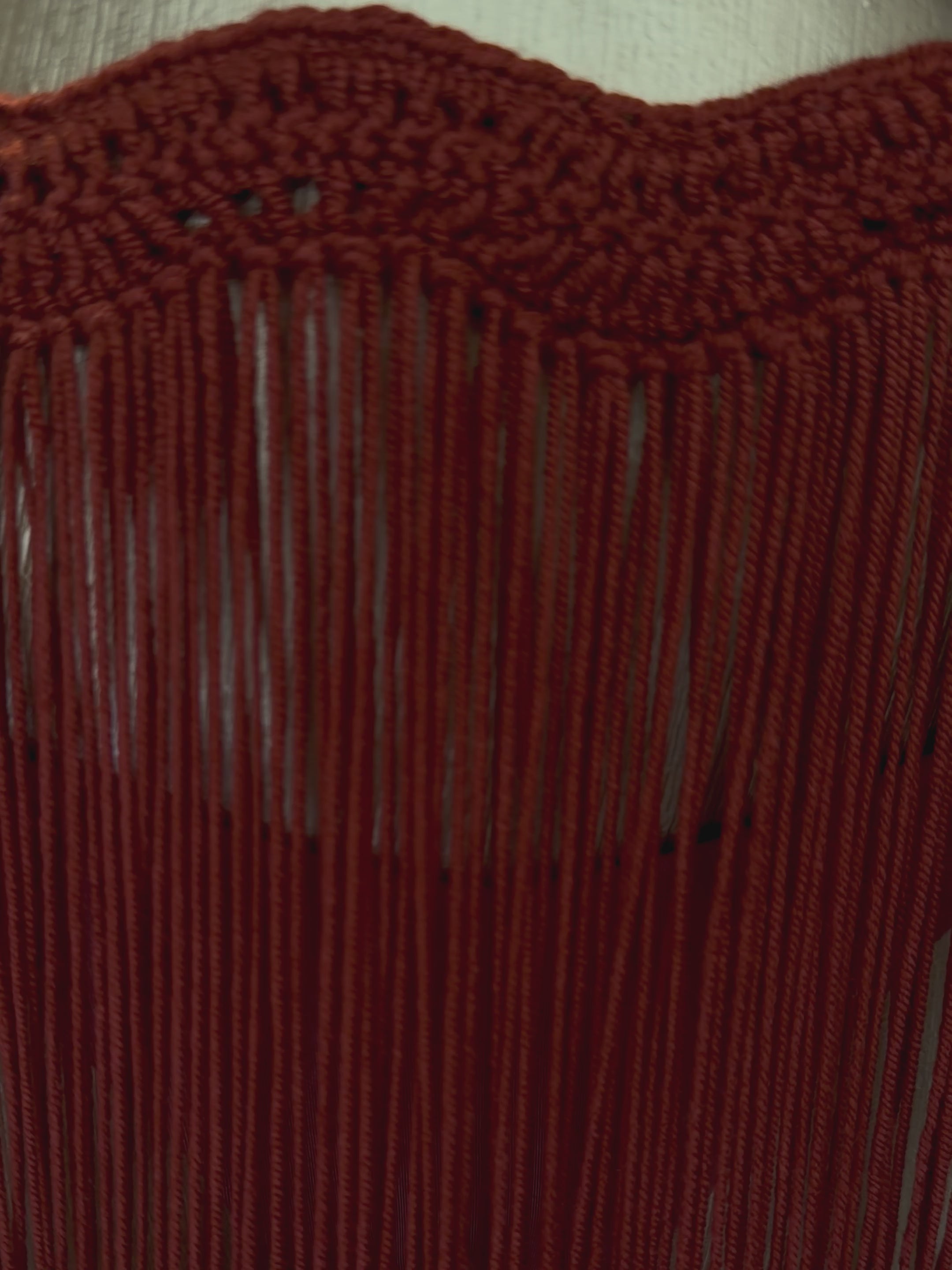 Video de la falda MINI TASSEL OLAS tejida a mano, con pretina de ondas, flecos, tiras ajustables y aro en tono madera clara.