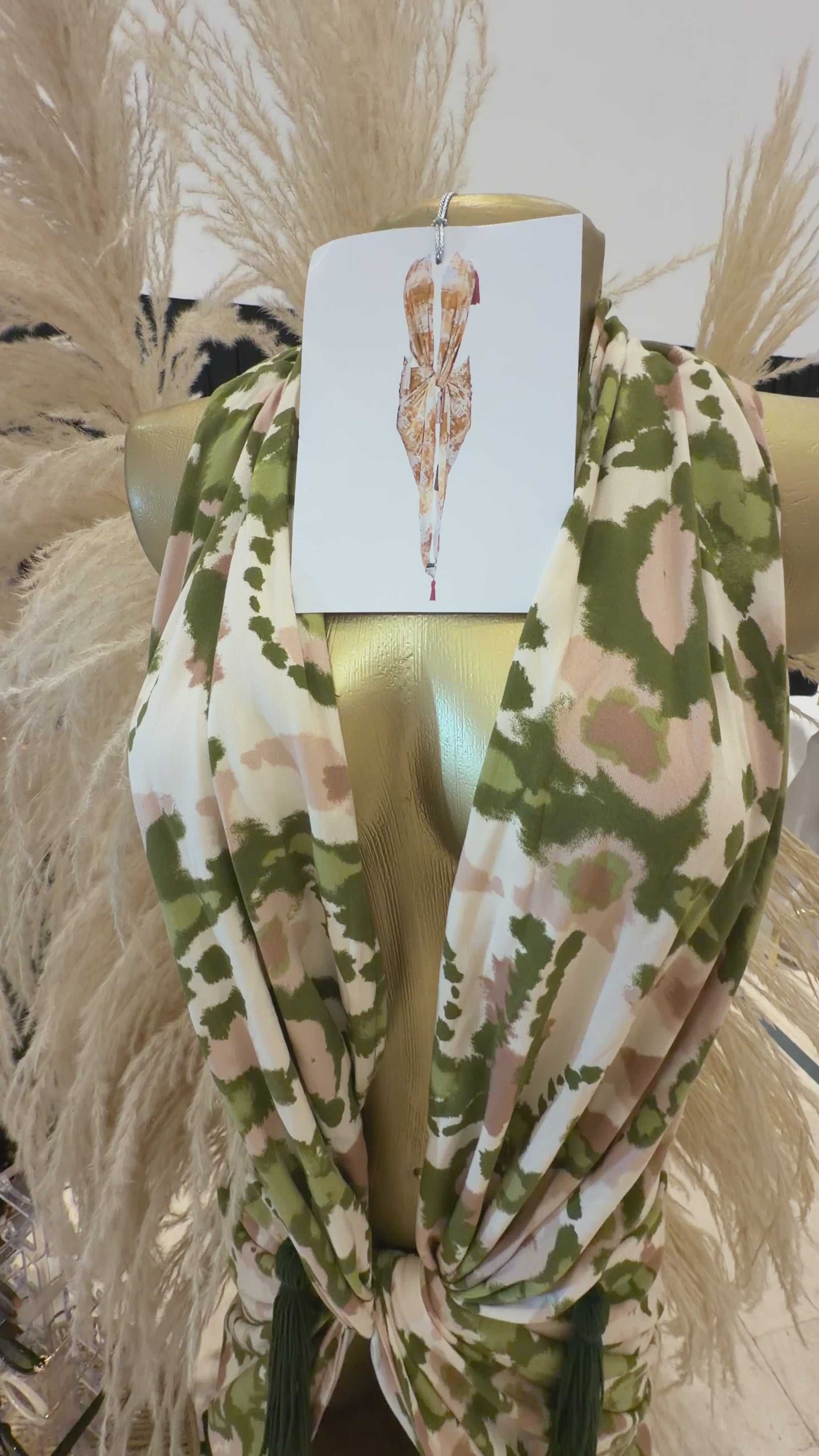 Video del pareo JUNGLE con estampado selva y apliques tassel tejidos a mano, ajustado al cuello para formar un vestido.