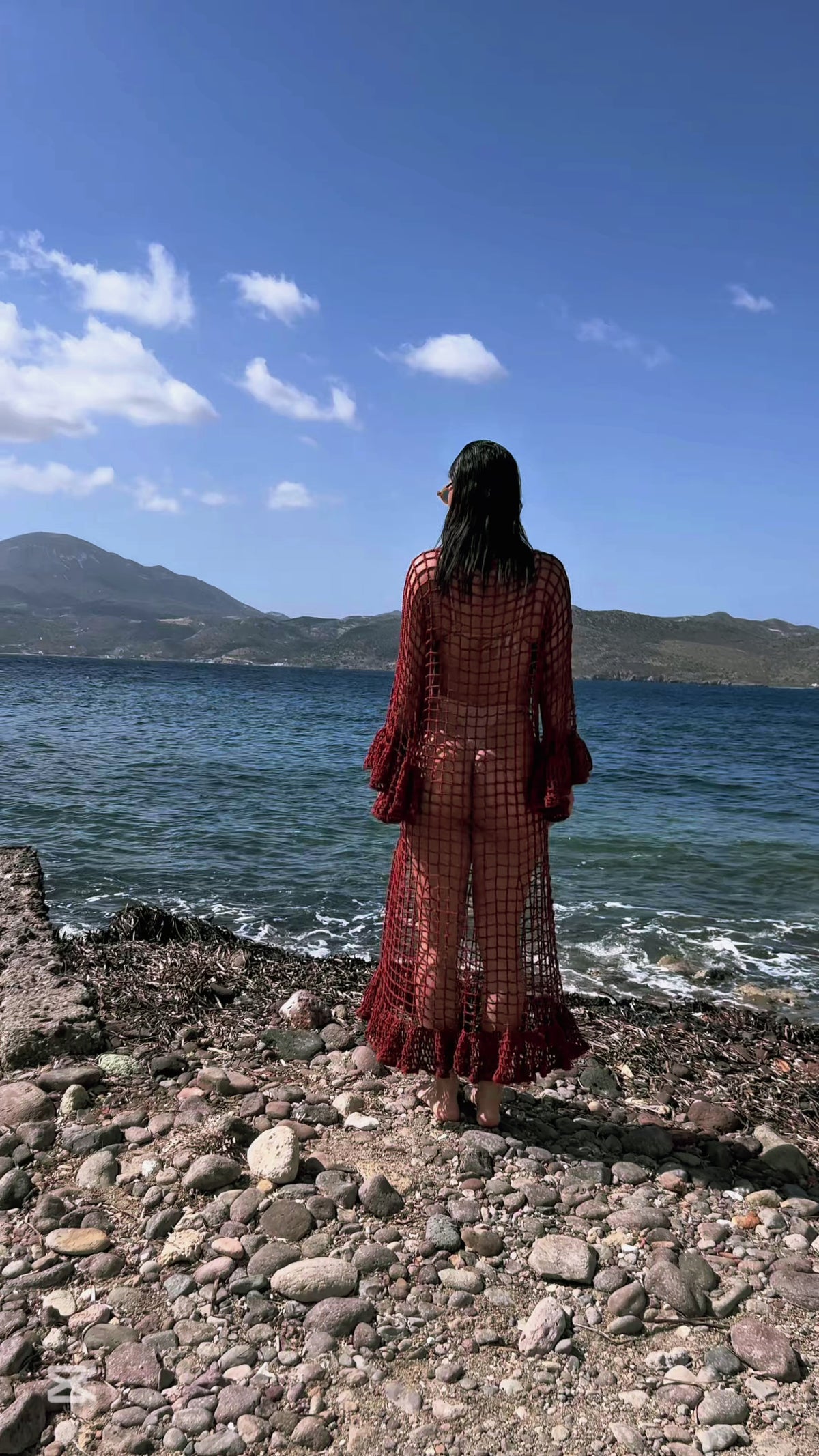 Video del vestido MILOS tejido a mano en crochet calado, con mangas acampanadas y volante en el ruedo, grabado en MILOS, Grecia.