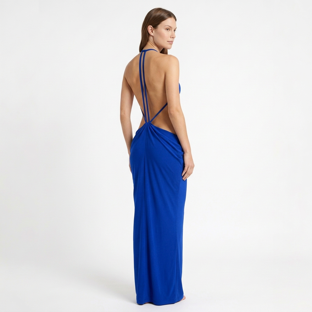 Vestido largo SELINI azul rey en modelo, vista de espalda en tres cuartos con tirantes finos y drapeado sobre la cadera.