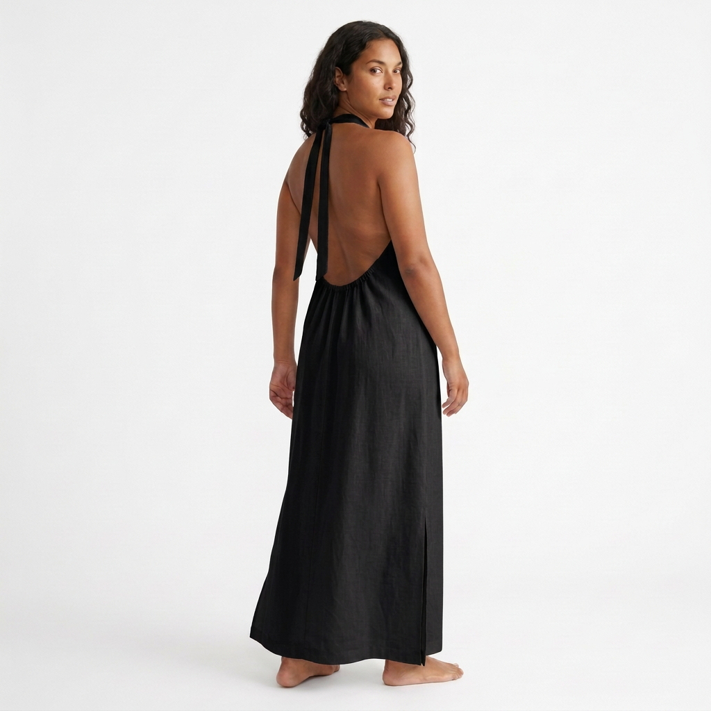 Modelo con vestido largo TULUM negro, vista posterior con espalda descubierta y tiras anudadas al cuello.