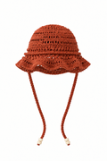 Sombrero YAQUE terracota tejido a mano en crochet, vista frontal sin modelo, con ala ondulada y tiras largas con cuentas